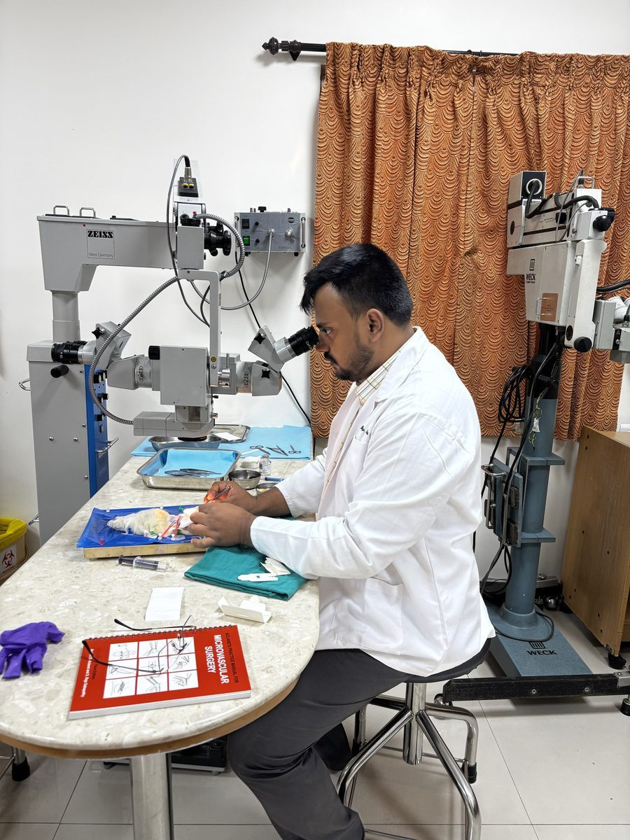 Dr. Bhargav Kuchu working under a surgical microscope